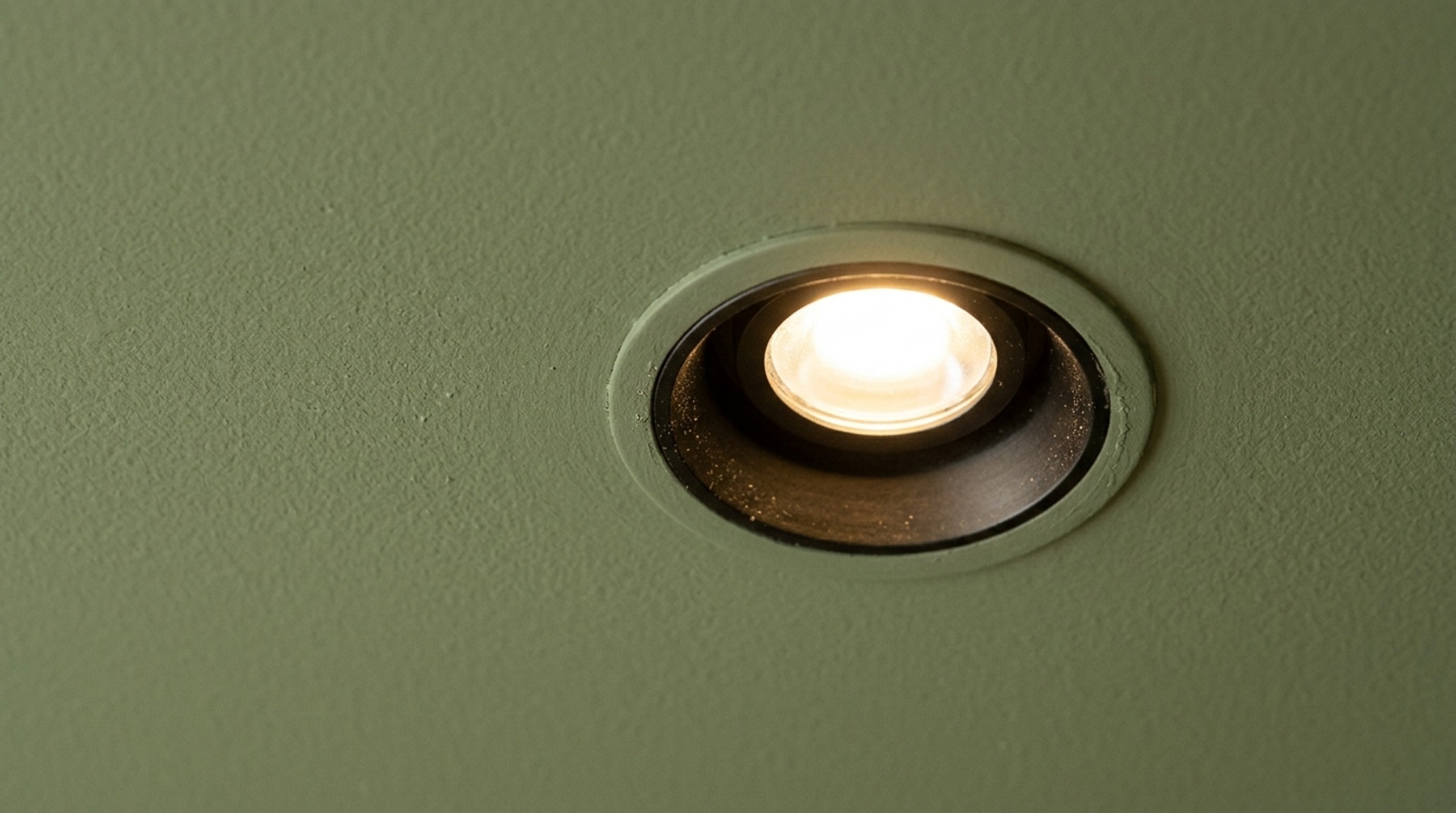 Close-up of a high-CRI lighting fixture casting a soft glow over a sage green wall, maintaining true color integrity in a small space. Close-up of a high-CRI lighting fixture casting a soft glow over a sage green wall, maintaining true color integrity in a small space.