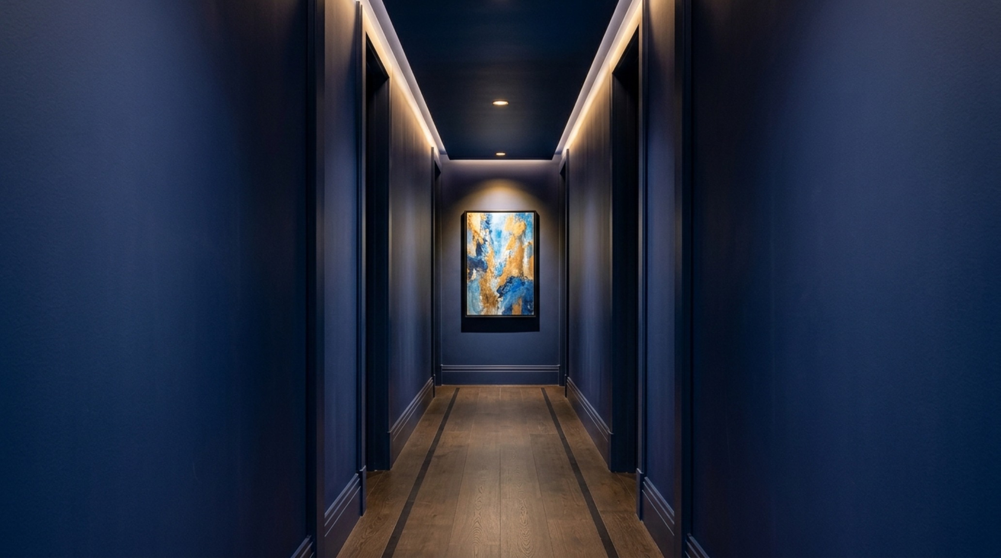 Editorial view of a hallway using blue color drenching to create architectural depth and sightline alignment toward a bright room. Editorial view of a hallway using blue color drenching to create architectural depth and sightline alignment toward a bright room.