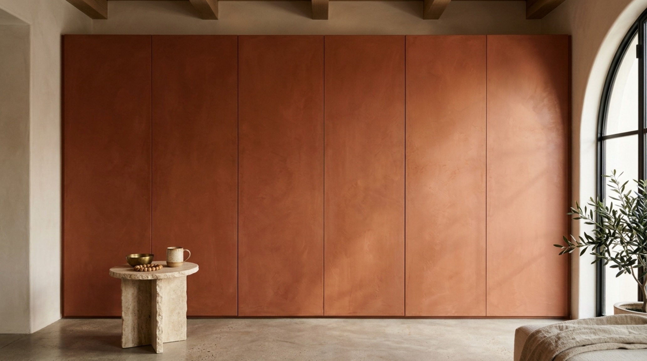 Built-in cabinetry painted in deep terracotta limewash to blend into the wall, illustrating concealment techniques. Built-in cabinetry painted in deep terracotta limewash to blend into the wall, illustrating concealment techniques.