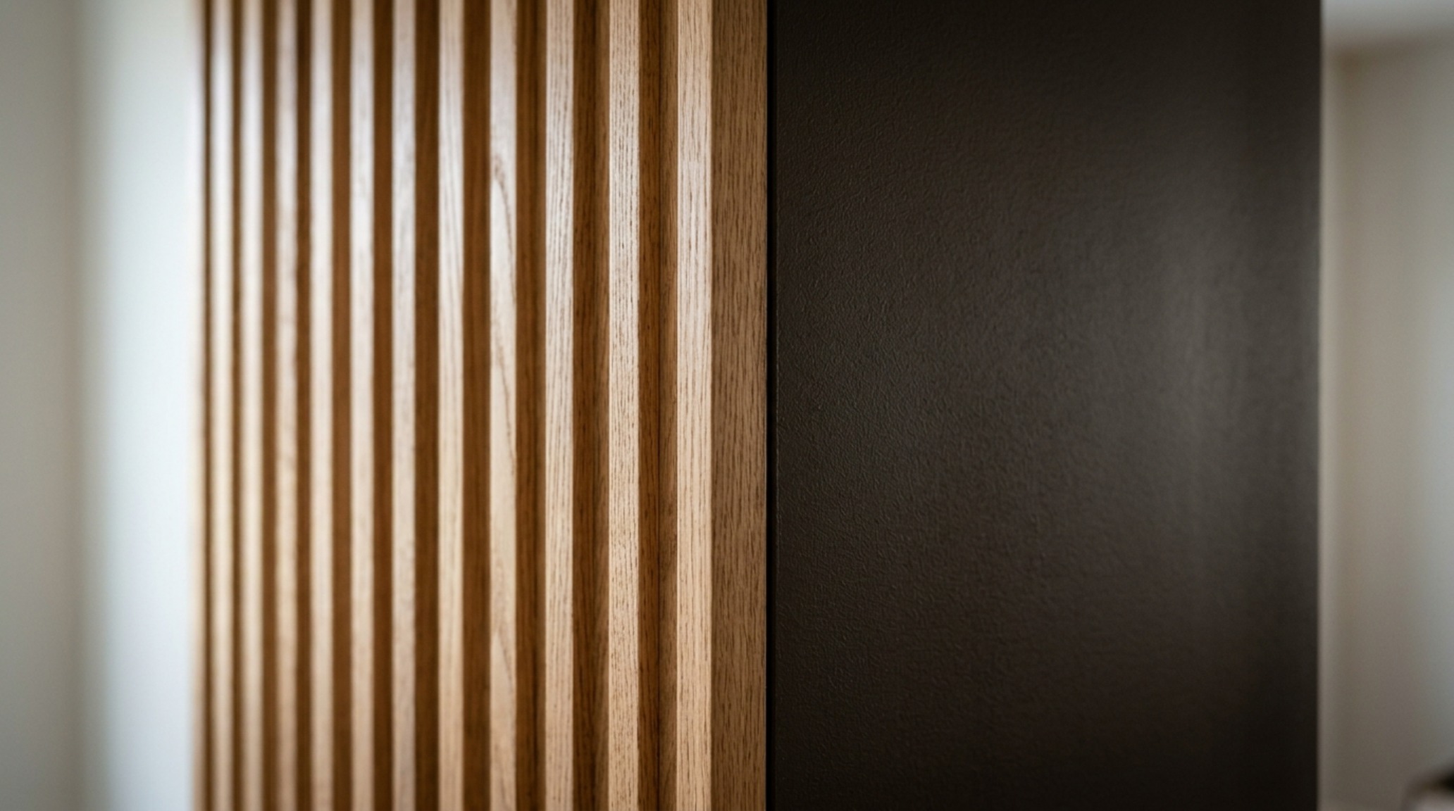 Detail shot of a fluted white oak wall panel meeting a matte mineral-painted ceiling with zero-bezel lighting. Detail shot of a fluted white oak wall panel meeting a matte mineral-painted ceiling with zero-bezel lighting.