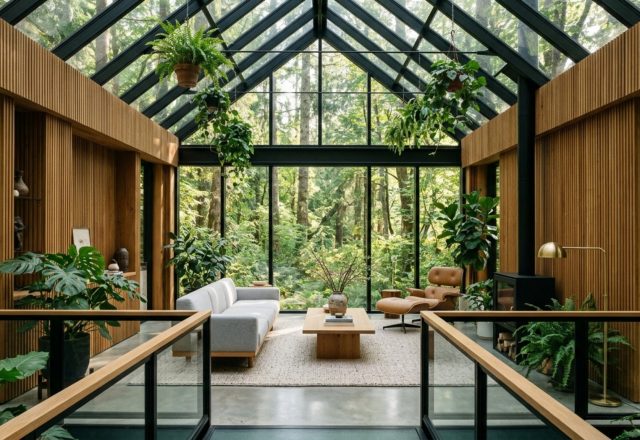 Wide-angle view of a concept house greenhouse experiment decor ideas layout showing a floating sofa, 36-inch walkways, and expansive glass walls with views of lush greenery.