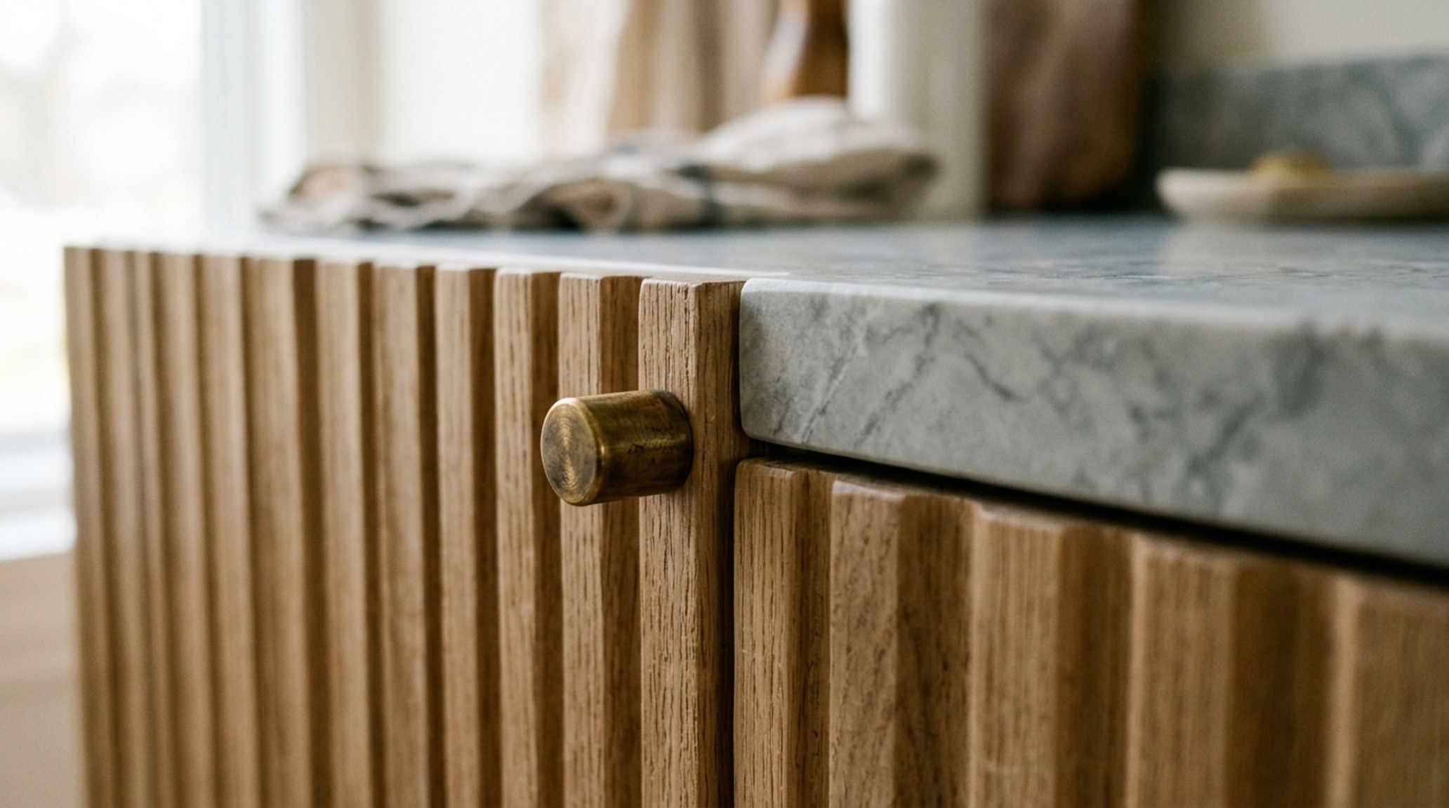 luxury kitchen cabinet floor plans textures highlighting a fluted oak island base paired with a thick honed quartzite countertop and under-mount sink.