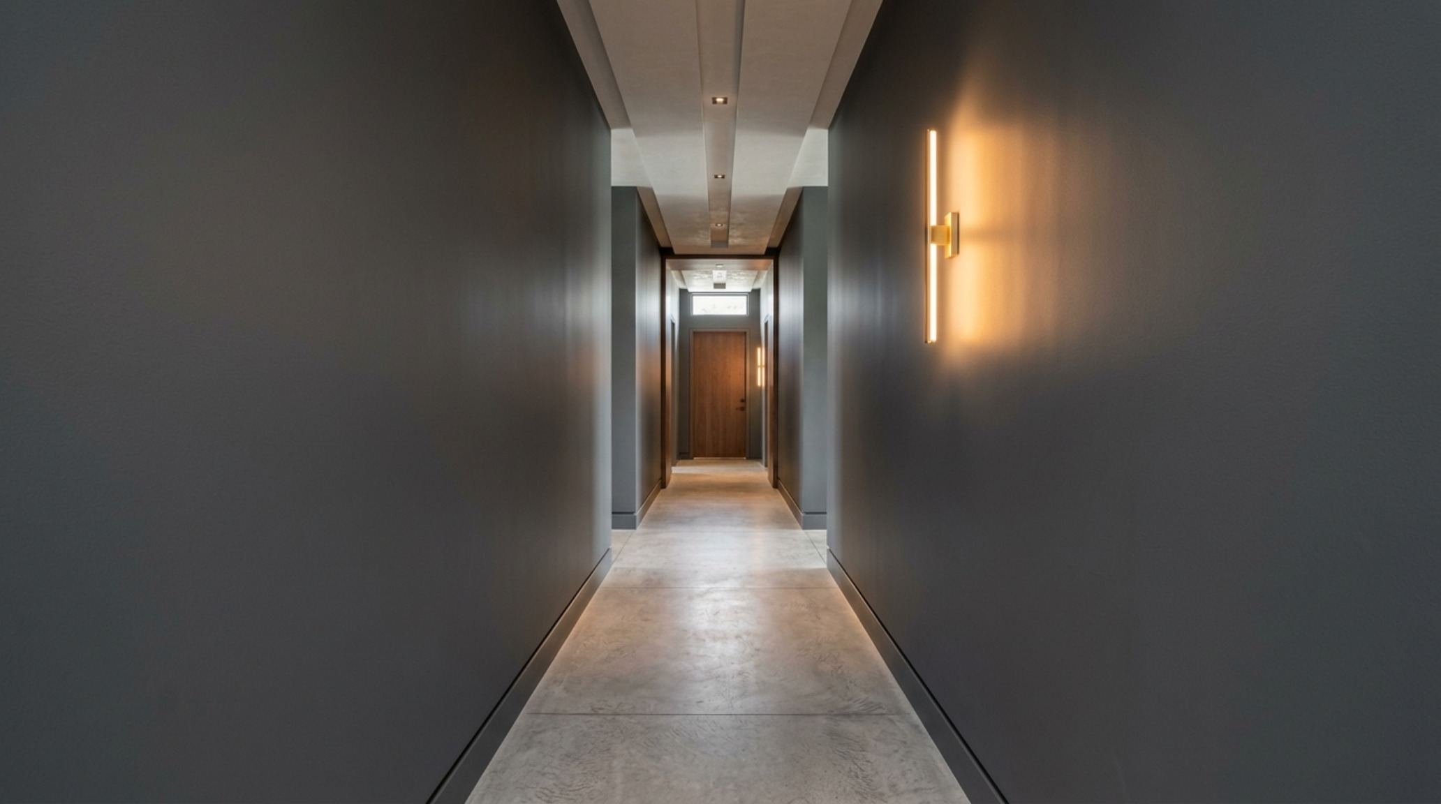 Symmetry and shadow play on a flat-finish corridor wall featuring modern flat paint decor ideas ideas and architectural lighting that eliminates reflective glare.