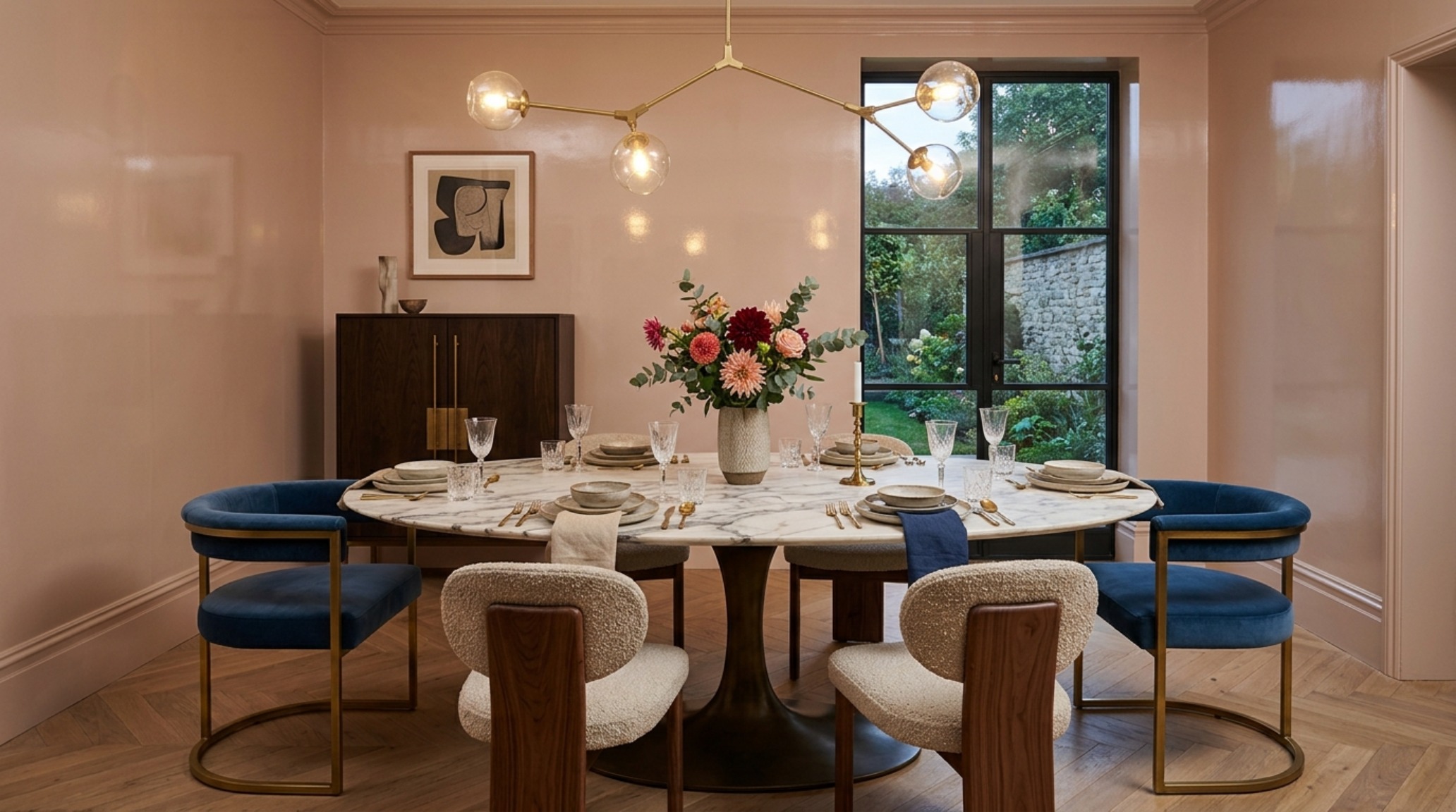 A sophisticated dining room layout showing Fawn Galli New York apartment decor ideas ergonomics with 30-inch chair clearances and a custom marble table under warm 2700K pendant lighting.