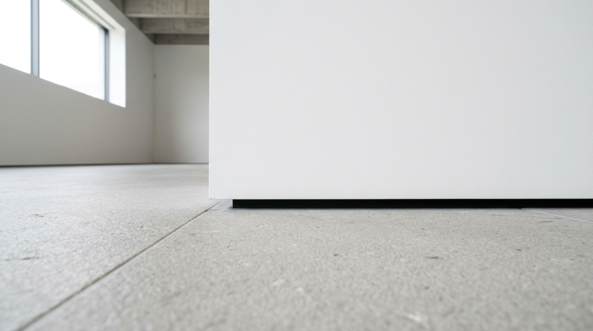 minimalist structural design detail of a 1/2 inch shadow gap reglet at the intersection of a concrete floor and white wall minimalist structural design detail of a 1/2 inch shadow gap reglet at the intersection of a concrete floor and white wall
