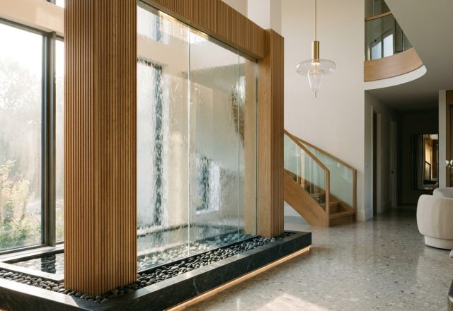 custom glass water features integrated into a modern foyer with low-iron tempered glass and precision weir for a seamless water sheet