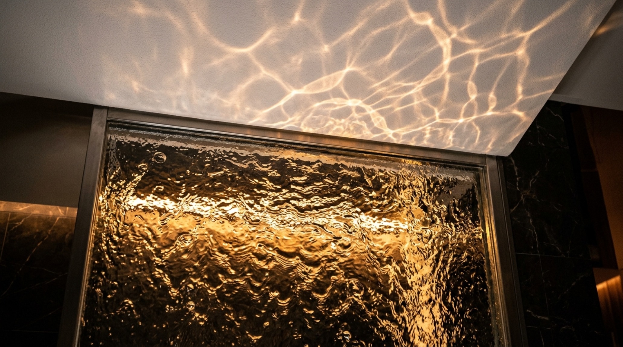 LED lit water walls with warm 2700K lighting casting caustic reflections on a Swiss Coffee painted ceiling