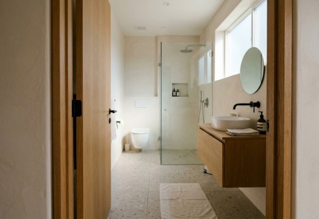 ideas for small bathrooms featuring a 32-inch clear walkway and a space-saving pocket door entrance in a neutral minimalist palette.