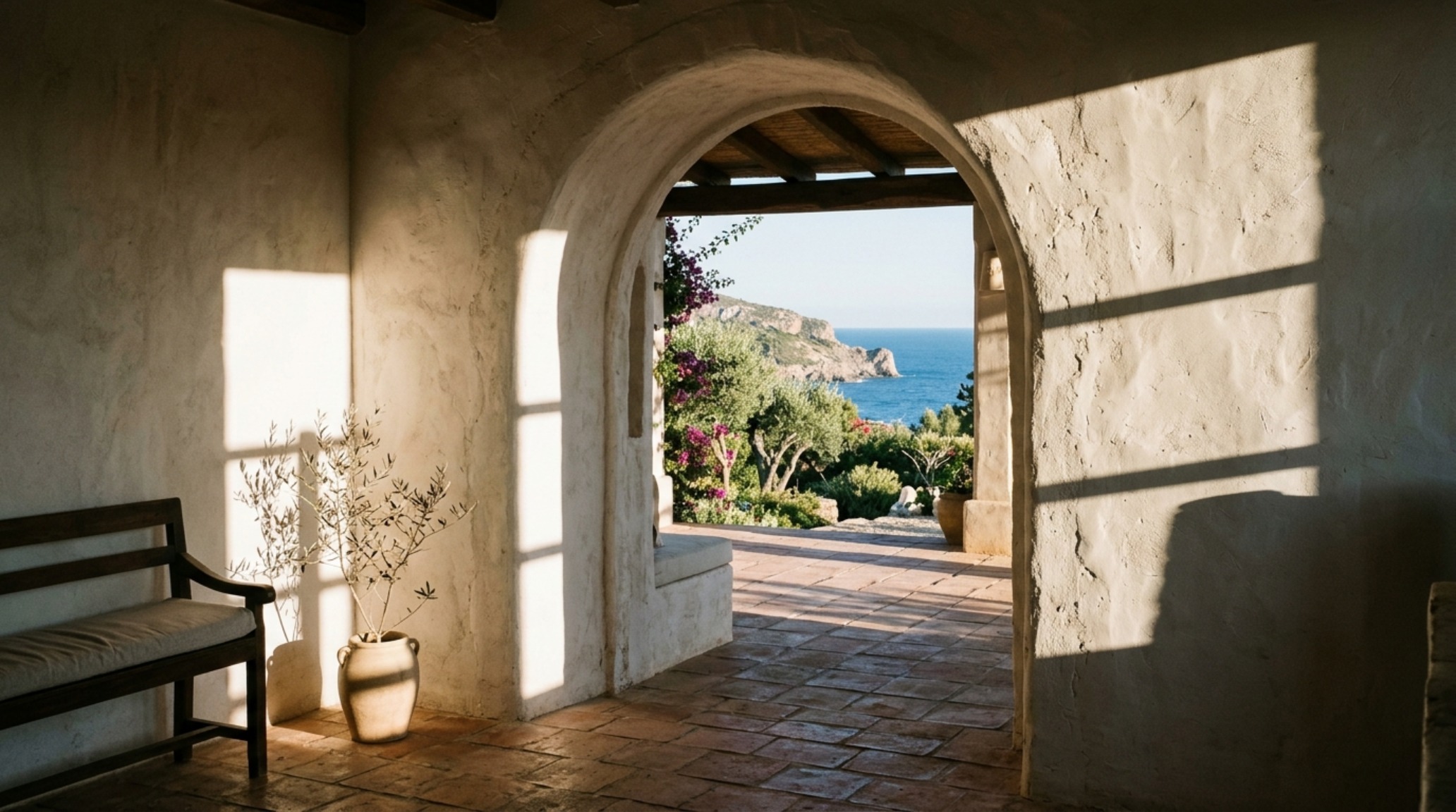 Architectural detail of a hand-troweled plaster archway reflecting afternoon sun, a hallmark of most beautiful islands world decor ideas.