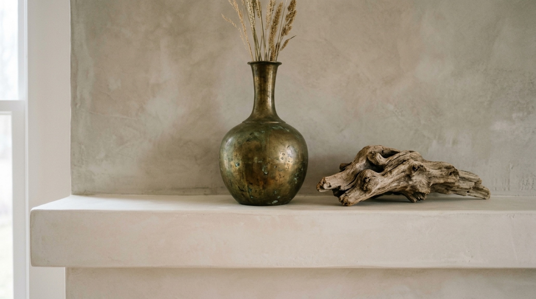 Close-up of a curated bookshelf with neutral-toned antique books and unlacquered brass objects, reflecting the luxury nate berkus favorite neutral color palette decor ideas textures.