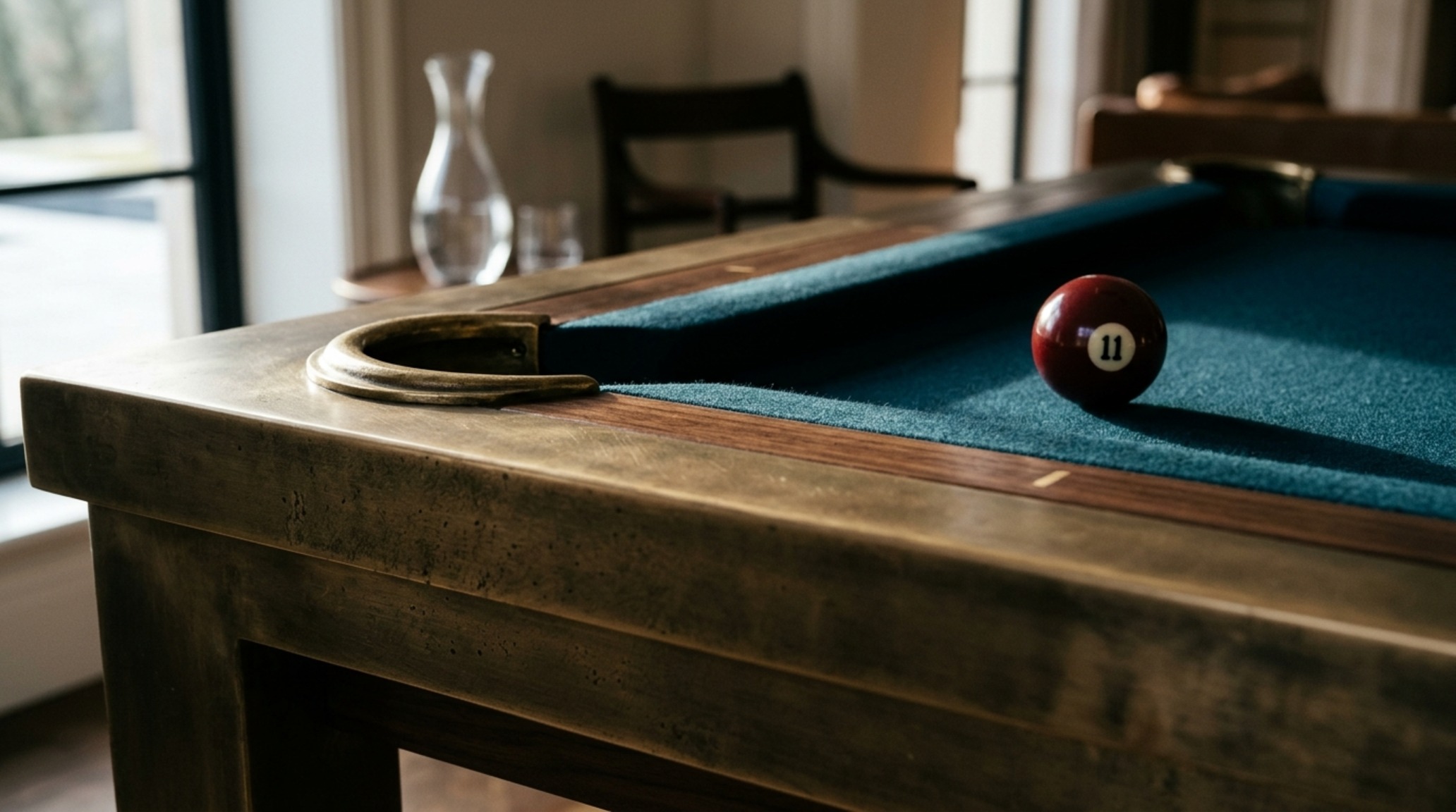 luxury pool dining tables textures illustrating the contrast between matte black powder-coated steel and worsted wool cloth