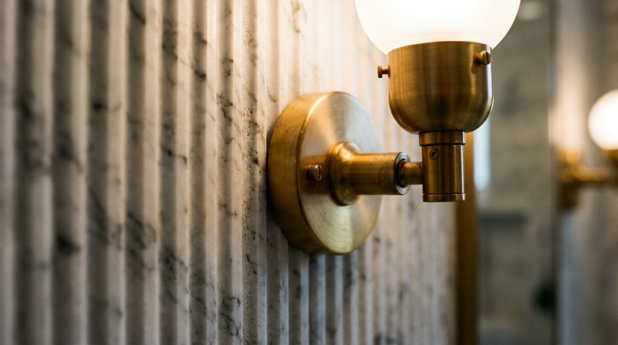 luxury small bathroom solutions textures highlighted by a close-up of fluted marble wall panels and a solid brass sconce emitting a high CRI 90+ warm glow. luxury small bathroom solutions textures highlighted by a close-up of fluted marble wall panels and a solid brass sconce emitting a high CRI 90+ warm glow.