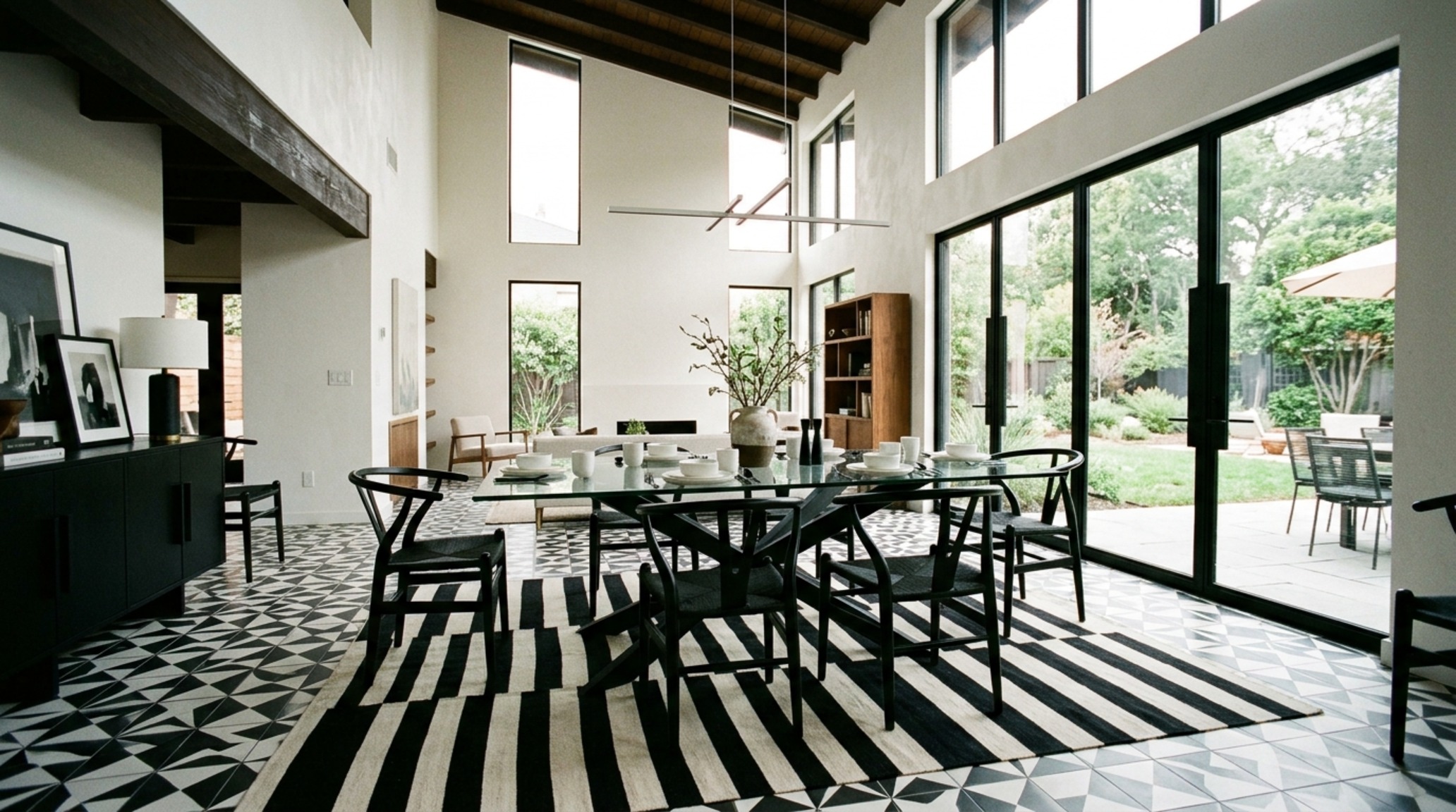 Geometric high-contrast flooring in a dining space with a 30-inch chair clearance and a sculptural marble table. Geometric high-contrast flooring in a dining space with a 30-inch chair clearance and a sculptural marble table.