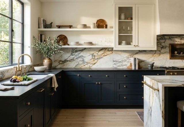 A stunning high-contrast kitchen featuring Farrow and Ball Railings base cabinets and Benjamin Moore Swiss Coffee upper cabinets with polished Calacatta Borghini marble backsplash.