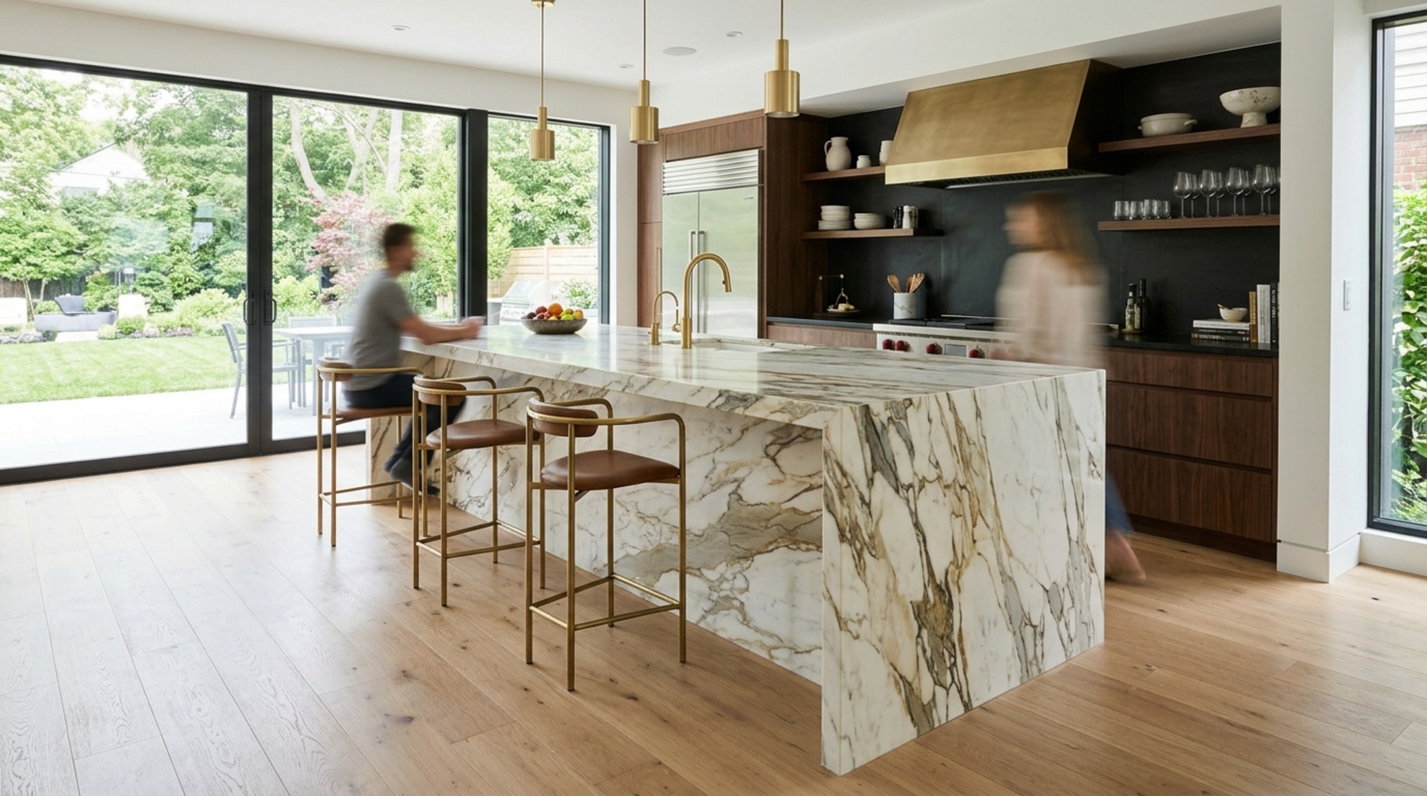waterfall island design cost illustrated by a dramatic bookmatched Calacatta marble island in a high-ceilinged open-concept kitchen