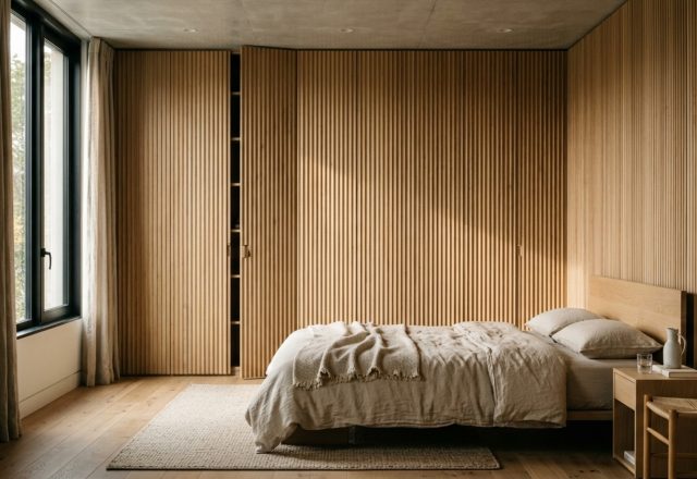 hidden storage furniture integrated into a floor-to-ceiling fluted white oak millwork wall with seamless push-to-open doors and minimalist shadow gaps.