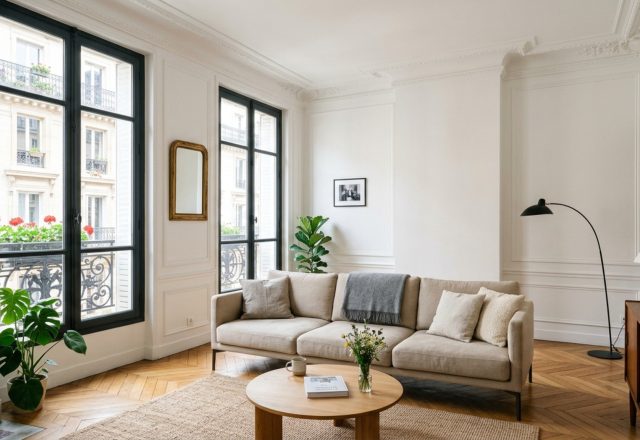 Small living room layout strategies featuring a low-profile sofa on walnut legs to maximize floor plane visibility and architectural sightlines.