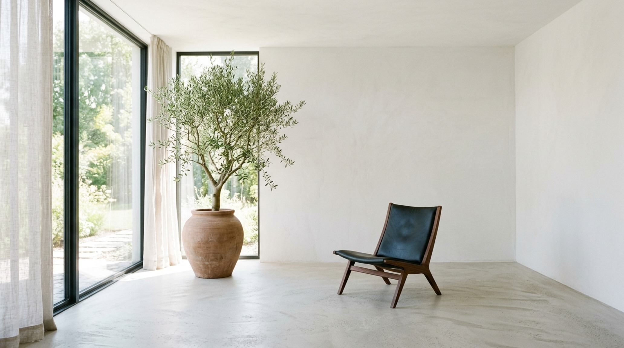 Minimalist home styling guide emphasizing negative space and a single travertine plinth as a focal point in an airy living area.