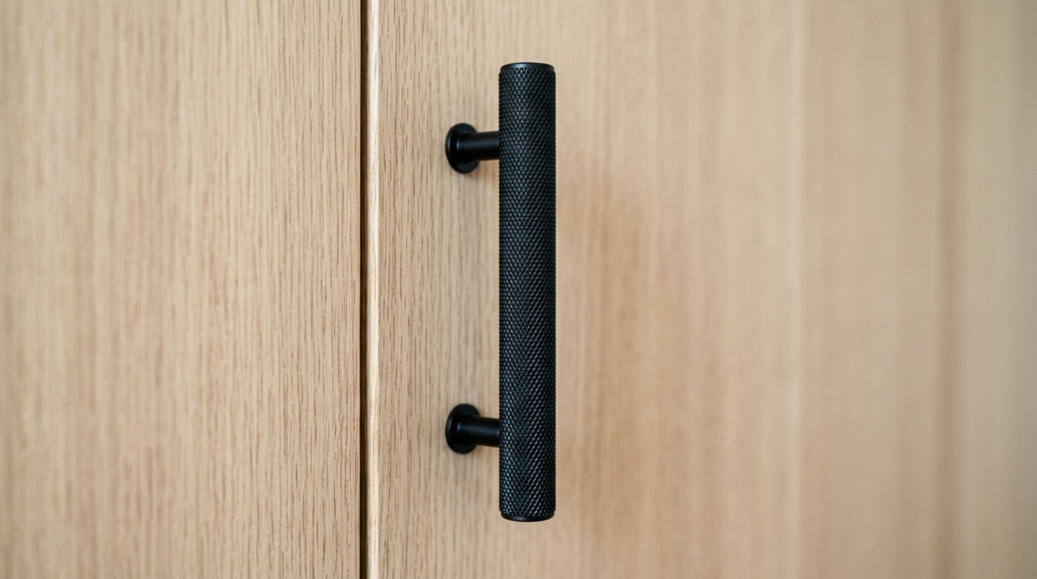 Matte black cabinet hardware installed on custom rift-sawn white oak cabinets, showcasing the graphic contrast and precision-engineered reveals of a modern layout. Matte black cabinet hardware installed on custom rift-sawn white oak cabinets, showcasing the graphic contrast and precision-engineered reveals of a modern layout.
