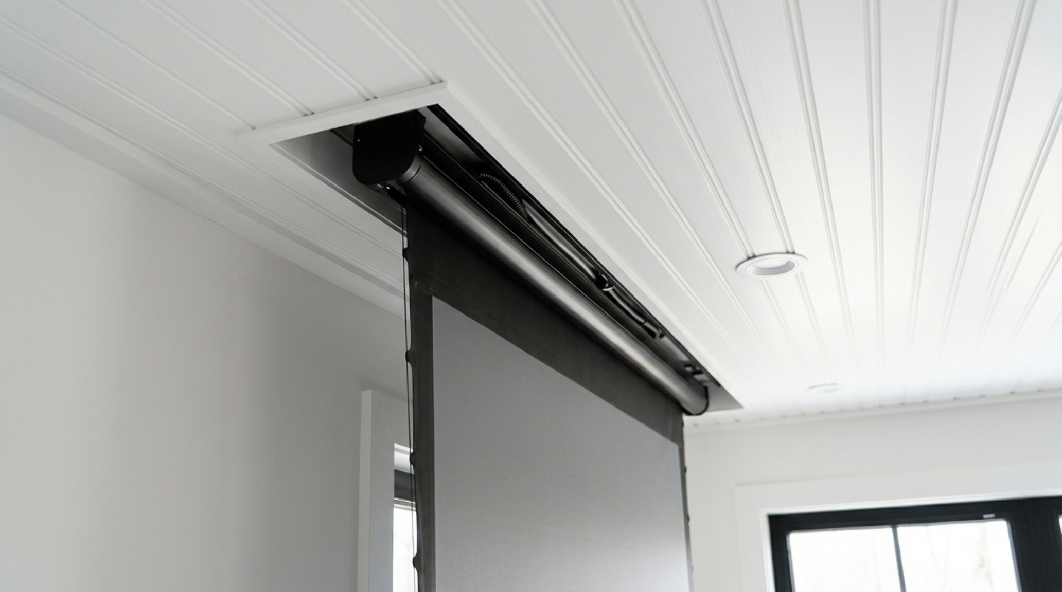 Detailed view of a recessed ceiling pocket for a motorized retractable porch screen, showing the 'invisible' technology used in high-end renovations.