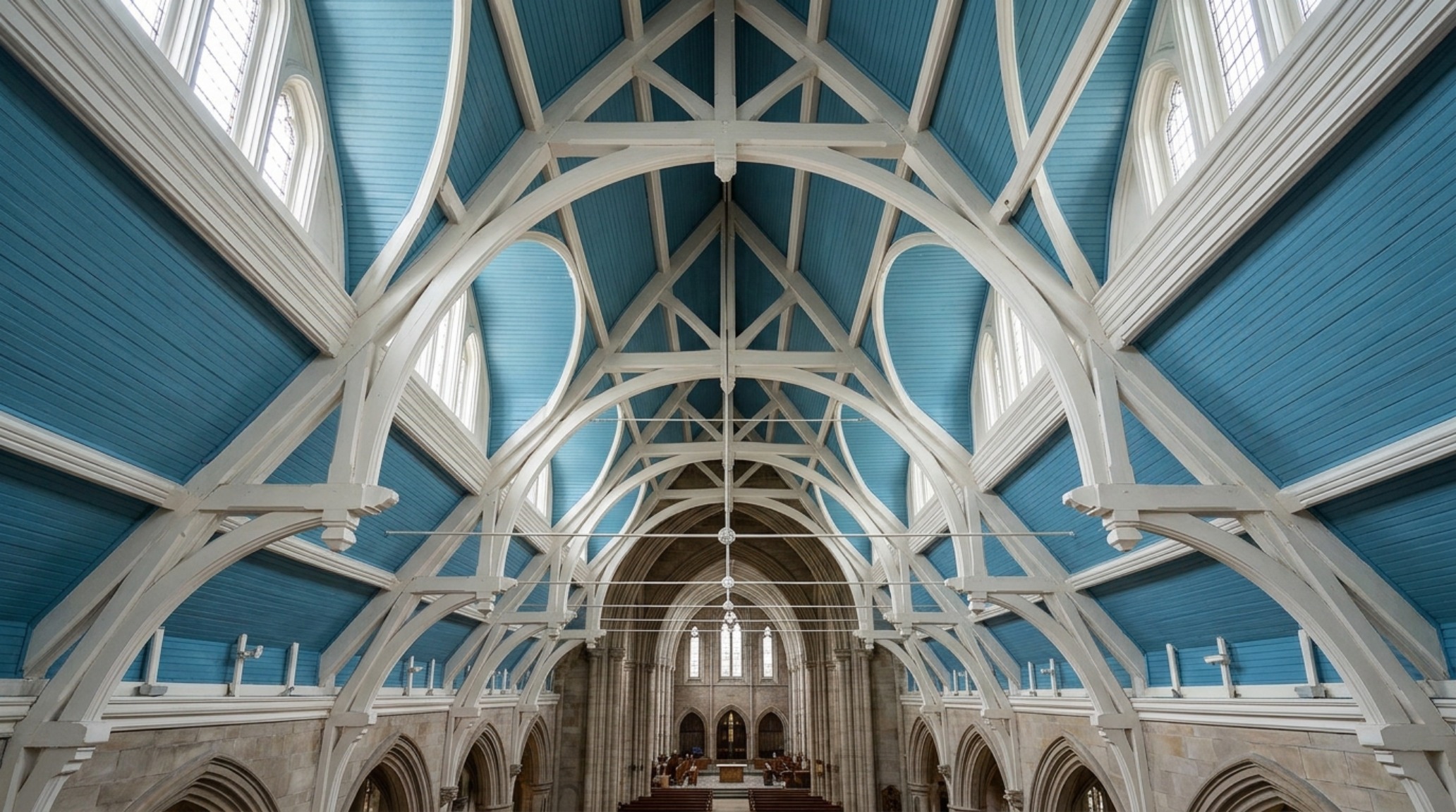 Close-up of a vaulted cathedral ceiling with soft blue beadboard in Benjamin Moore Palladian Blue, showing the architectural detail of a modern porch enclosure design.