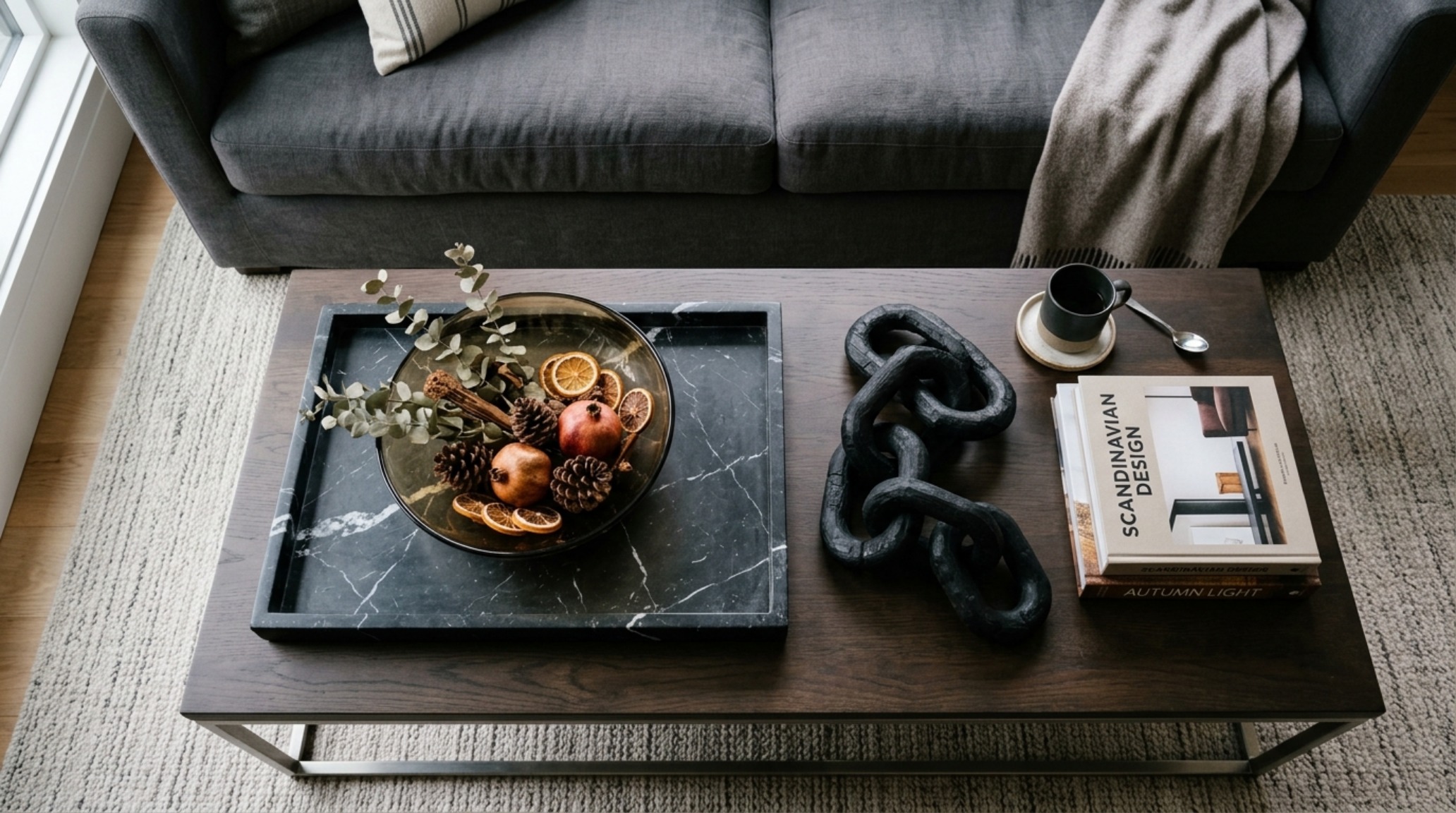 Luxury halloween home accents featuring mouth-blown smoked glass vessels and Nero Marquina marble decorative elements on a coffee table.