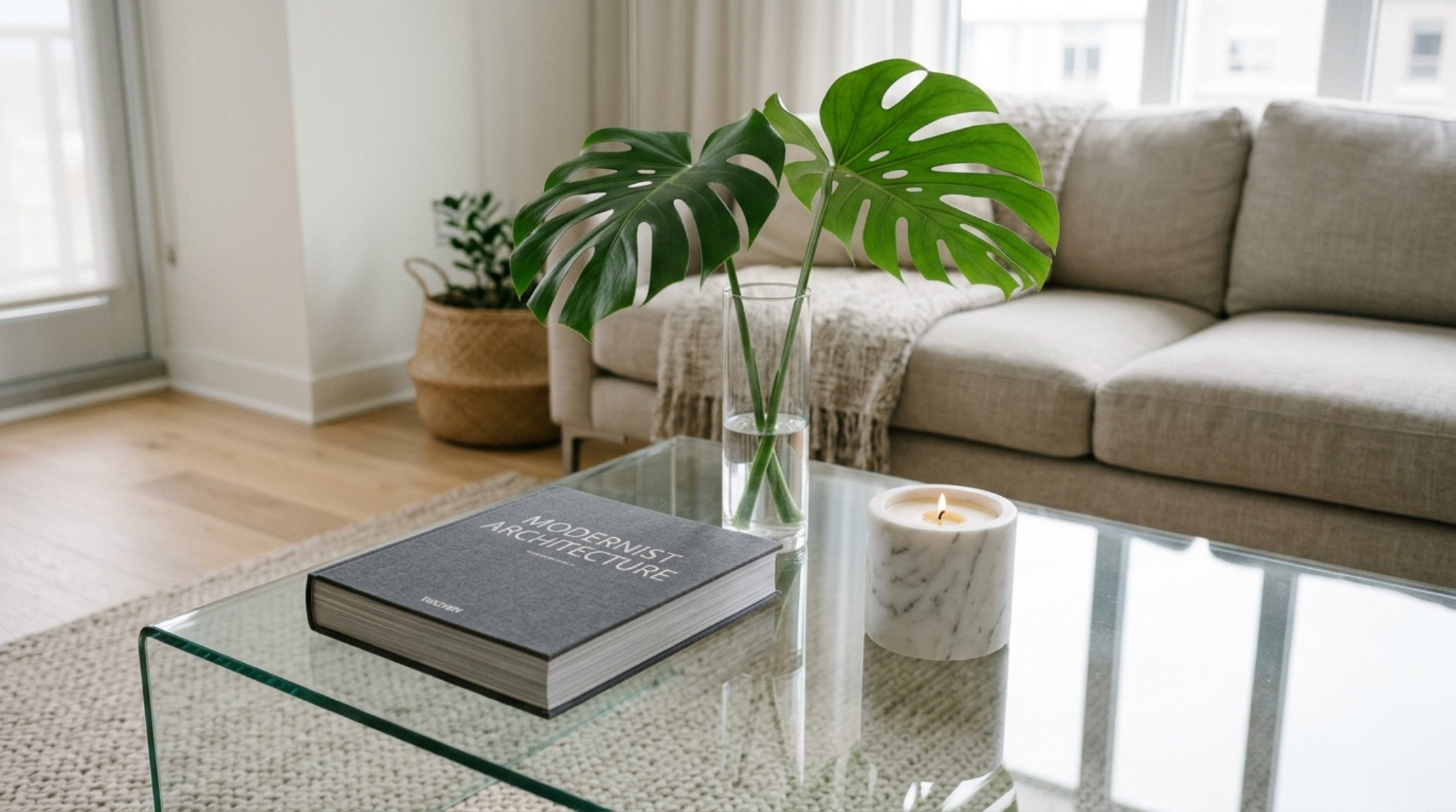 Minimalist glass coffee table centerpieces including a single sculptural branch in a clear glass vase on a low-profile table. Minimalist glass coffee table centerpieces including a single sculptural branch in a clear glass vase on a low-profile table.
