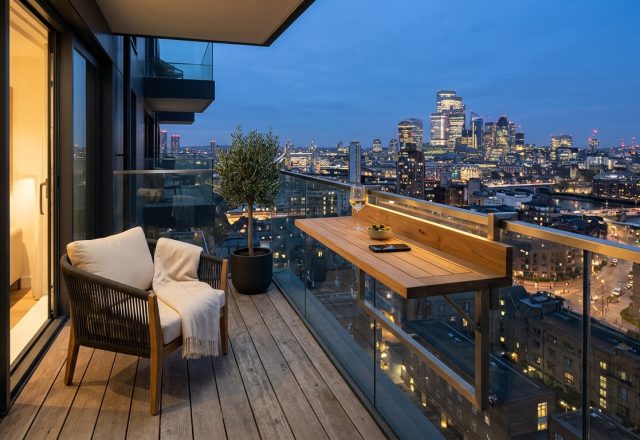 Editorial view of a modern apartment balcony featuring a teak railing table and a 24-inch clear walkway for optimized small apartment balcony ideas.