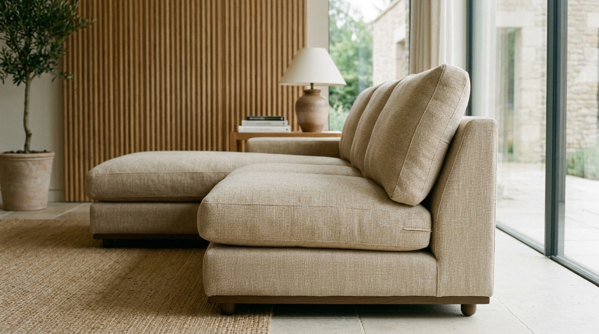 Detail shot of a deep seat sectional highlighting ergonomic lumbar support cushions and a sleek, low-slung silhouette in an urban loft.