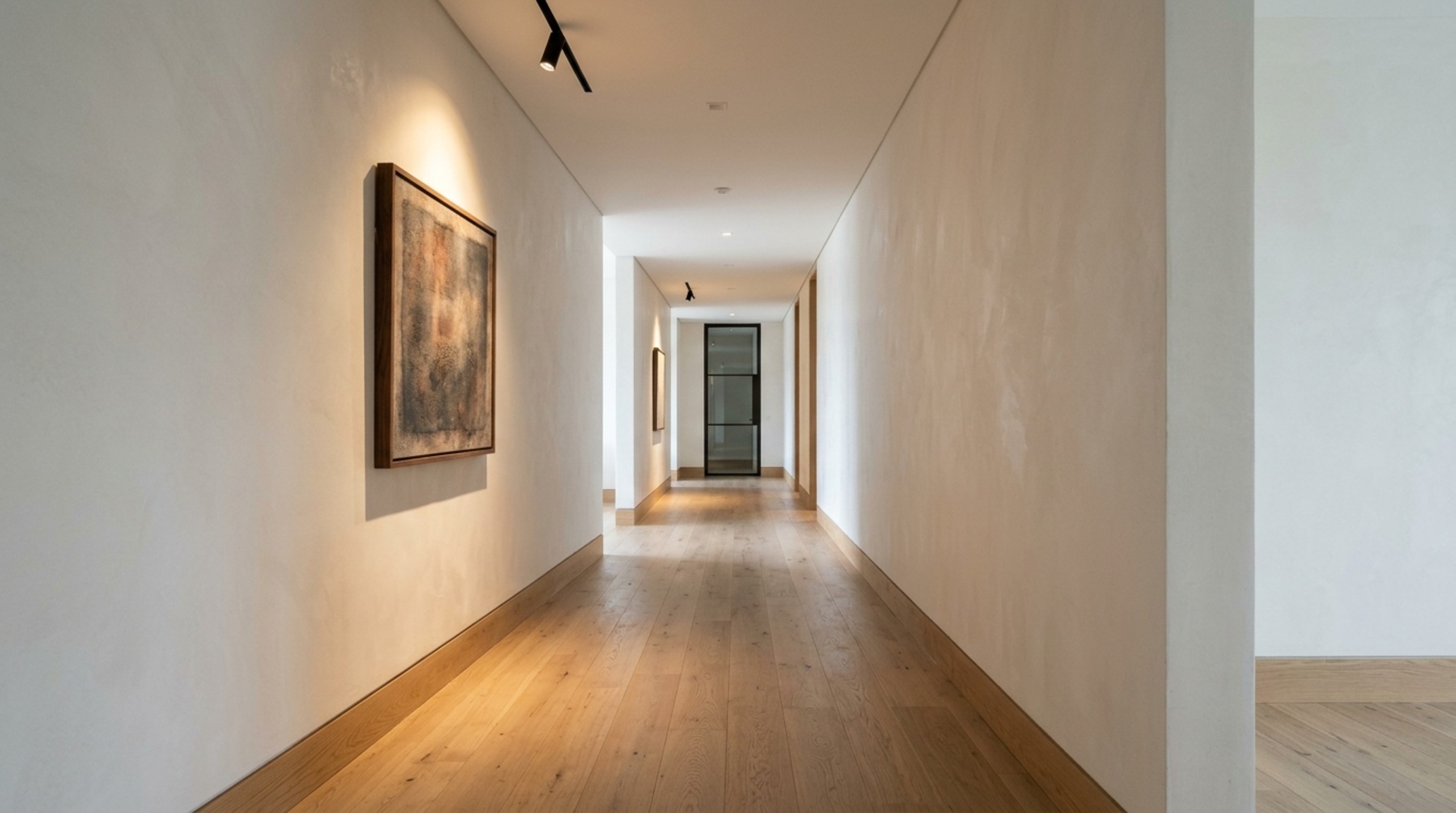 Residential circulation patterns in a gallery-style hallway with matte plaster walls and 36-inch primary paths between architectural vignettes.
