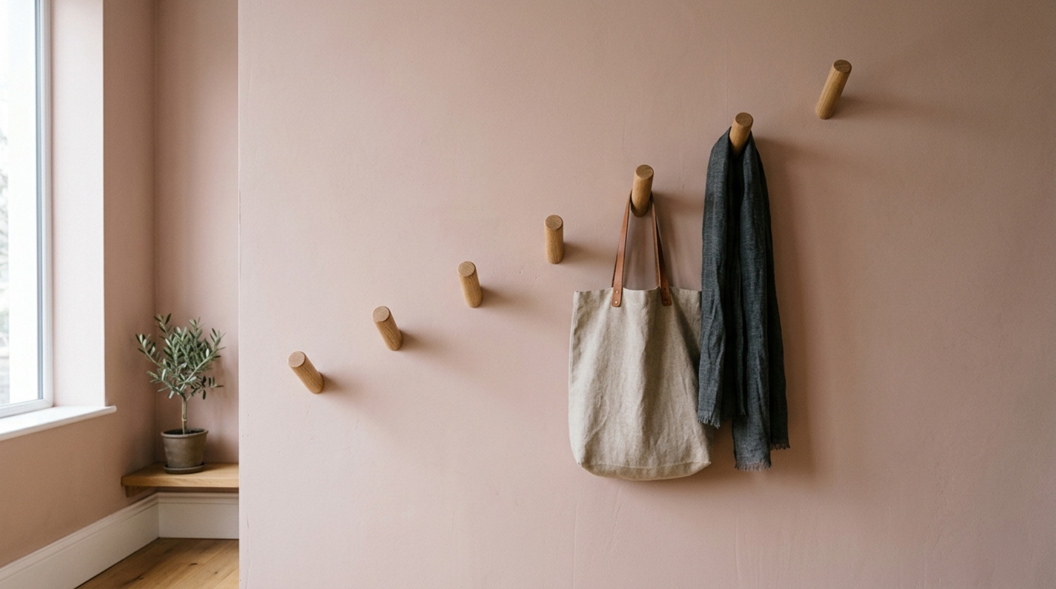 Minimalist coat rack DIY featuring a grid of staggered oak pegs on a warm plaster-finished wall with natural light. Minimalist coat rack DIY featuring a grid of staggered oak pegs on a warm plaster-finished wall with natural light.
