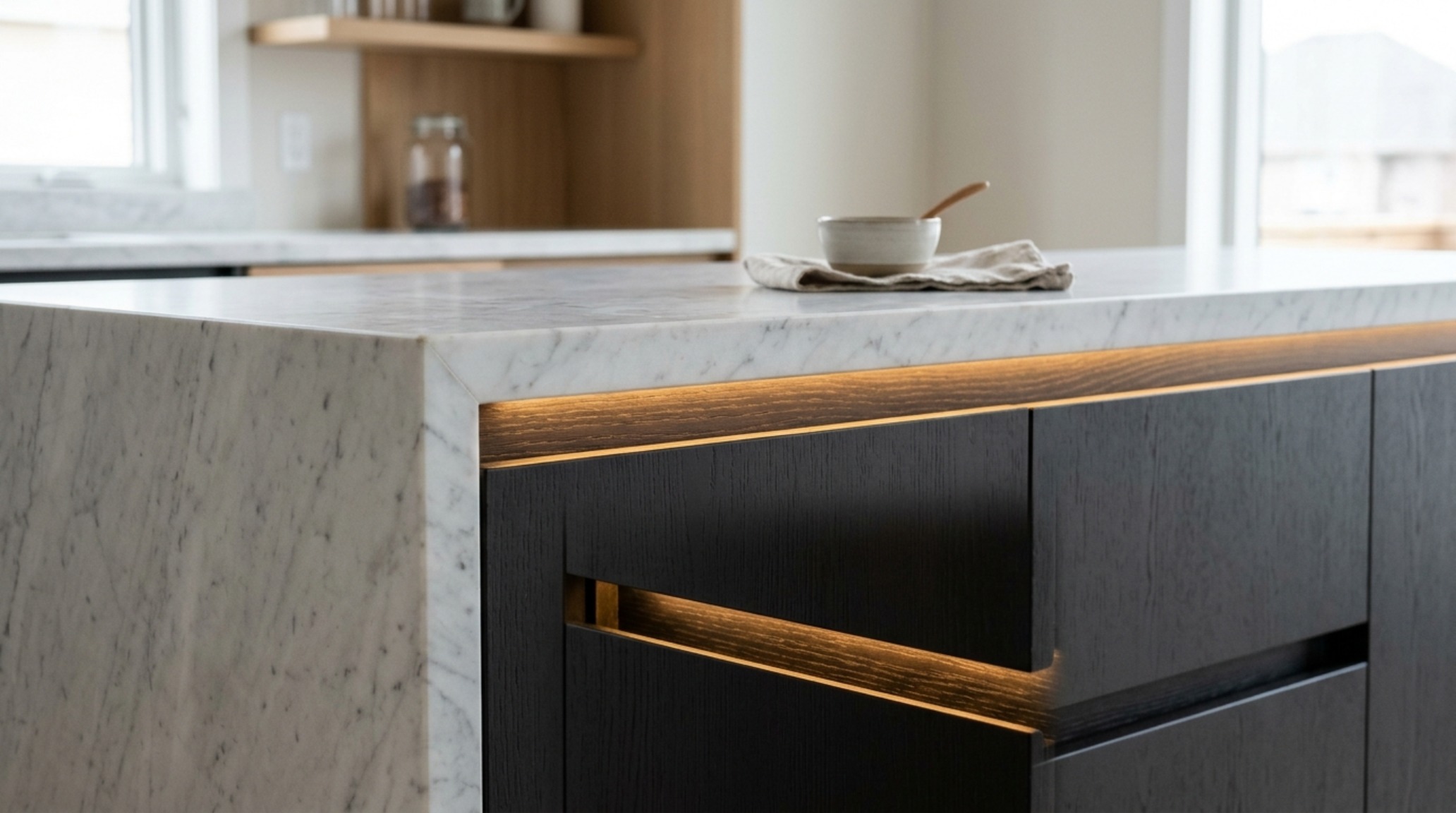 handleless kitchen cabinets with integrated finger channels and subtle LED accent lighting under a honed marble countertop. handleless kitchen cabinets with integrated finger channels and subtle LED accent lighting under a honed marble countertop.