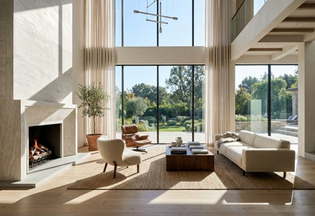 modern luxury living room featuring high-vaulted ceilings, floor-to-ceiling windows, and a minimalist limestone fireplace centered on a 36-inch architectural axis.