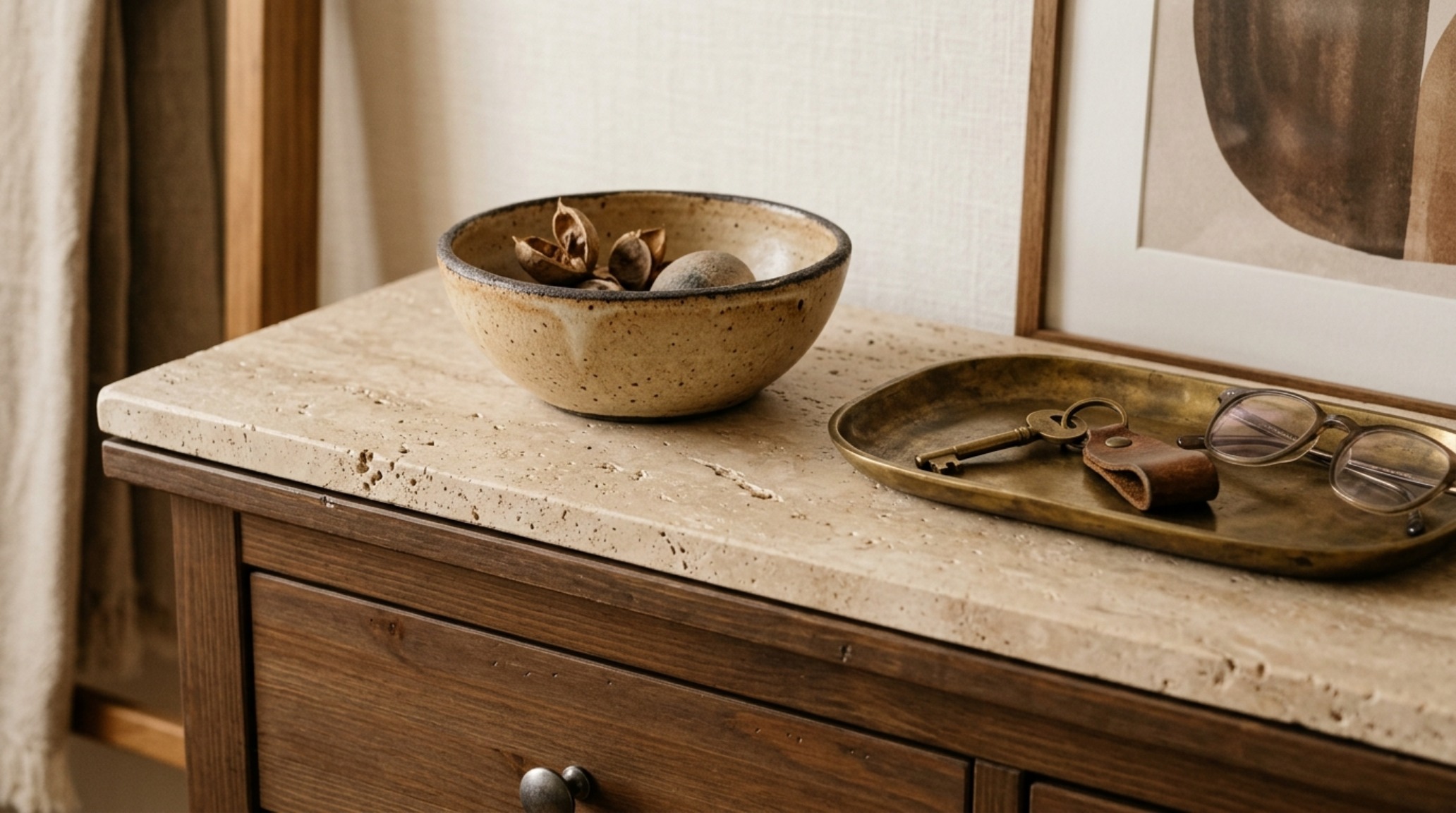 Close-up detail of an IKEA Hemnes shoe cabinet hack showing a honed travertine stone surface, a hidden charging station, and tactile materiality in a small entryway.