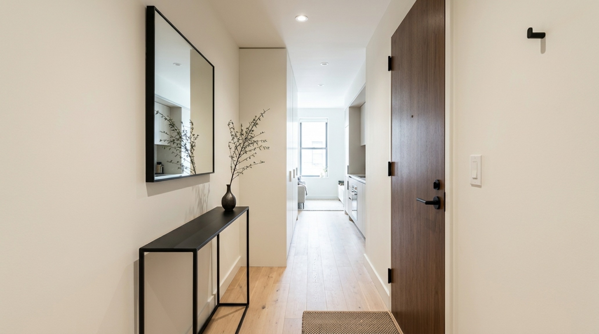 Narrow hallway design showcasing the use of Benjamin Moore Swiss Coffee paint and a slim 8-inch deep console to maintain clear sightlines.