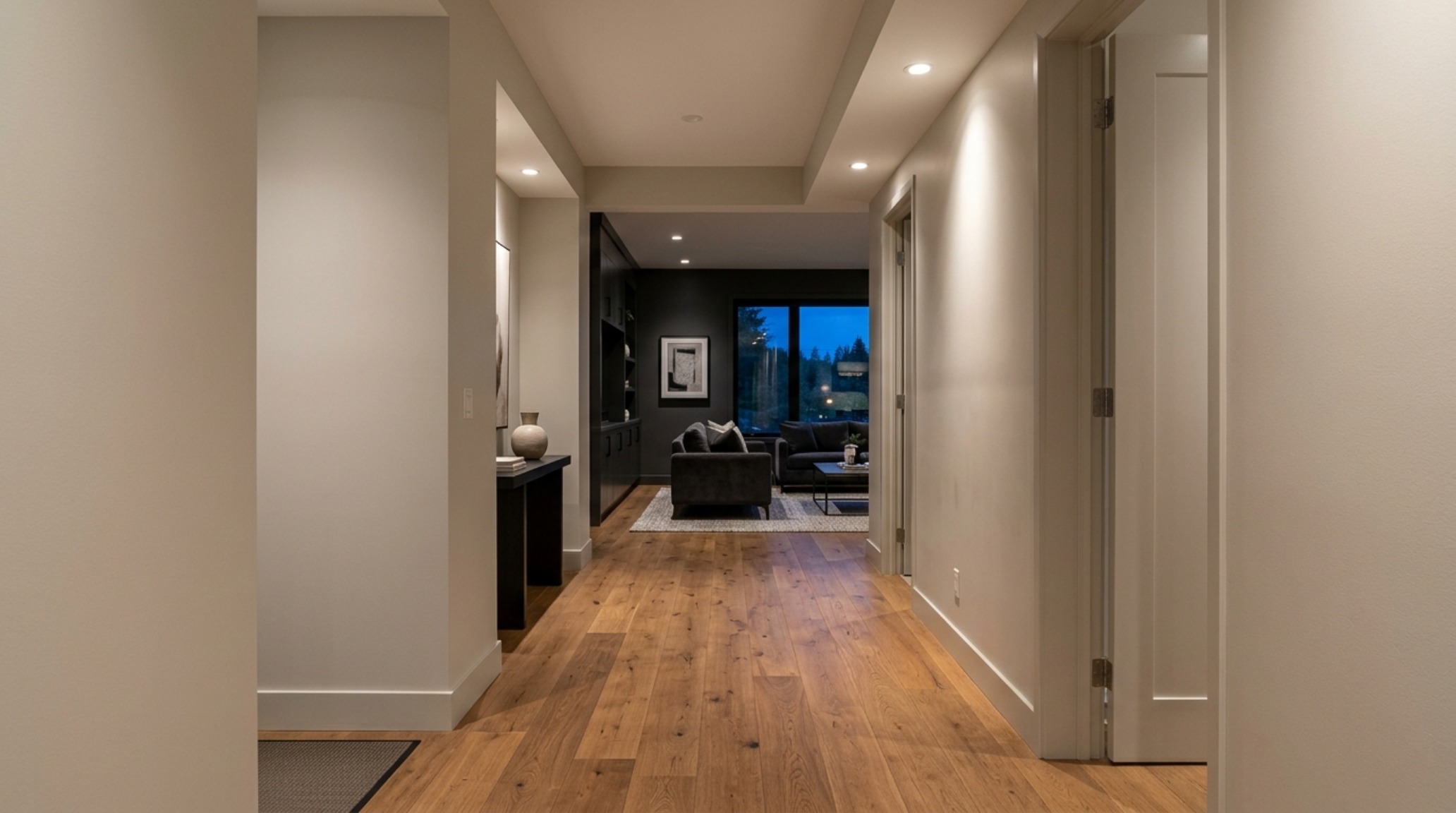 A hallway highlighting sightline alignment and the transition between different neutral wall palettes in a contemporary open-plan home. A hallway highlighting sightline alignment and the transition between different neutral wall palettes in a contemporary open-plan home.