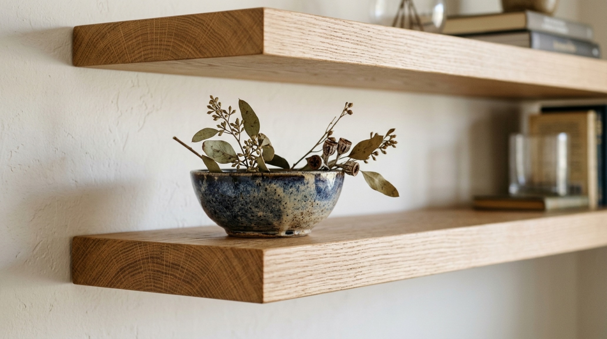 Detailed shot of a 4-inch thick floating shelf showing the seamless mounting and natural wood grain against a charcoal accent wall. Detailed shot of a 4-inch thick floating shelf showing the seamless mounting and natural wood grain against a charcoal accent wall.