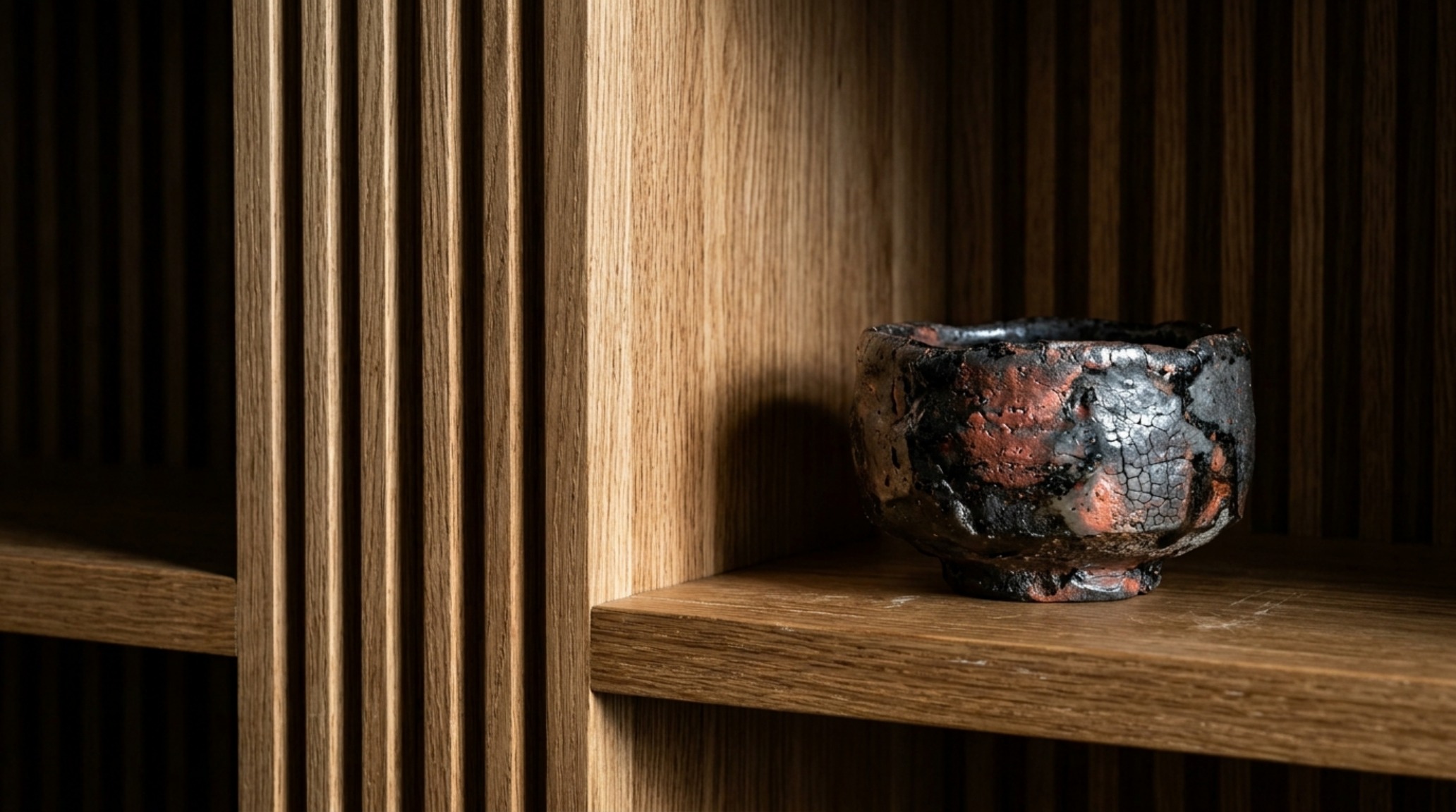 Architectural detail of fluted white oak shelving with high-resolution tactile textures and curated decorative vessels.