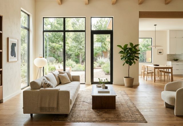 A sophisticated open-concept living room featuring Benjamin Moore Swiss Coffee walls, 36-inch clear walkways, and soft natural light from floor-to-ceiling windows.