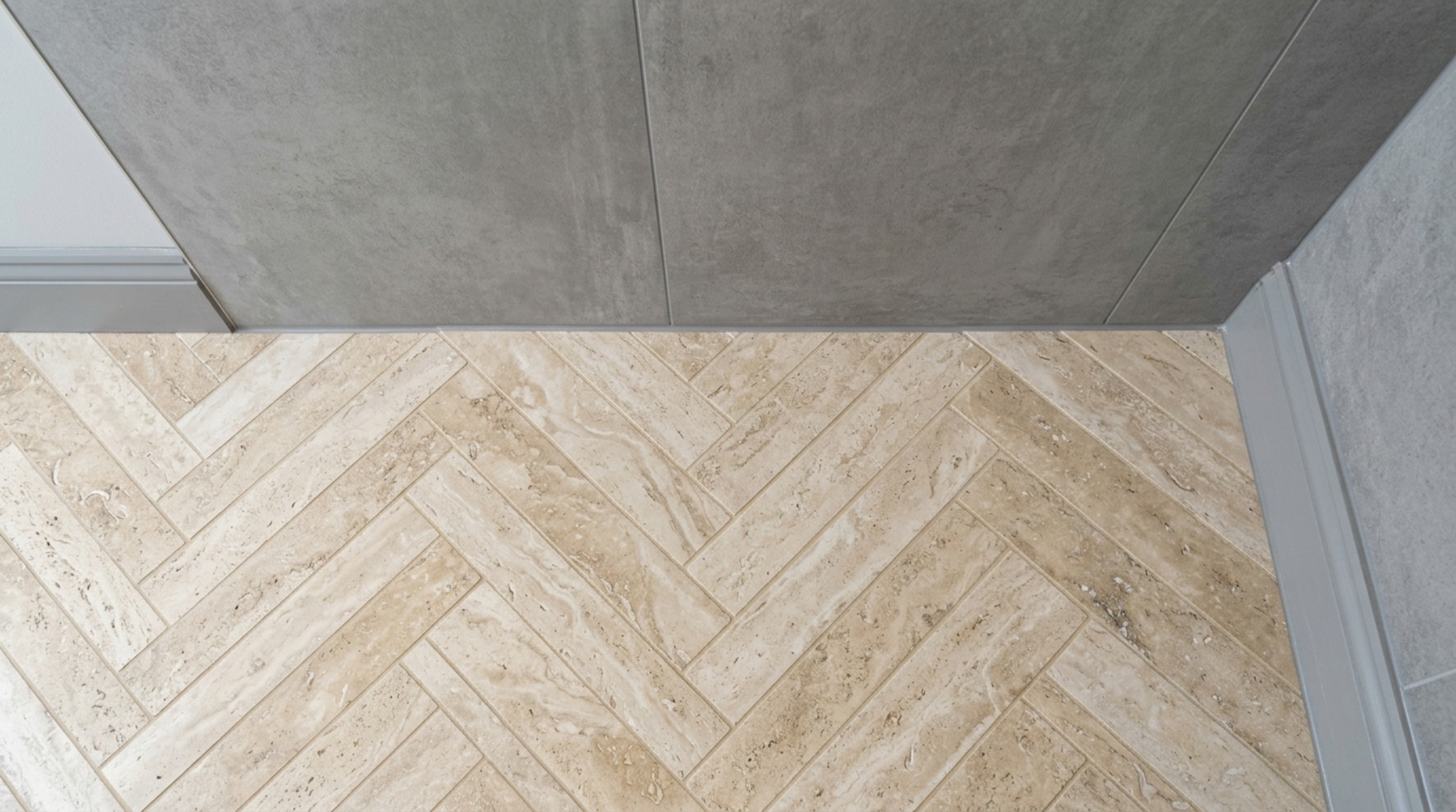 bathroom tile pattern trends featuring a classic herringbone floor layout transitioning into a large-format porcelain wall slab