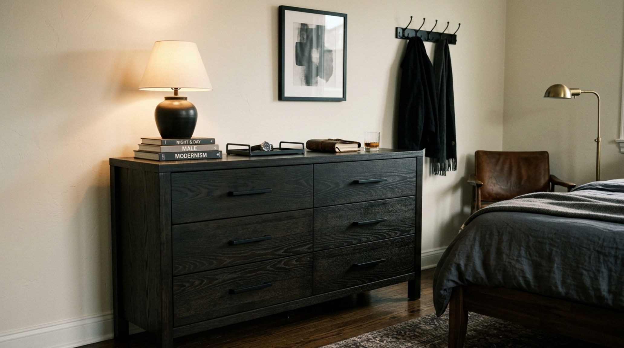 dark wood bachelor bedroom aesthetic highlighting an ebony-stained ash dresser with matte black hardware and soft task lighting