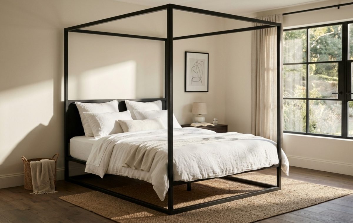 Minimalist black iron canopy bed frame in a master suite with white Belgian linen bedding and warm 2700K architectural lighting, demonstrating core canopy bed decor ideas.