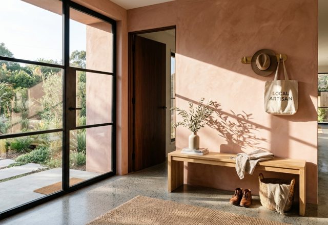 An entryway in a luxury prefab home featuring limewash walls in Farrow & Ball Setting Plaster and a minimalist oak console.