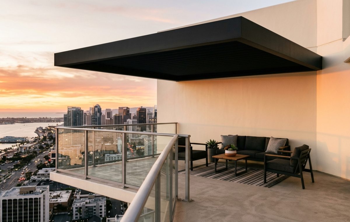 A sleek cantilevered patio cover structure expands the volume of a modern urban terrace, showcasing innovative small apartment balcony ideas with panoramic city views.