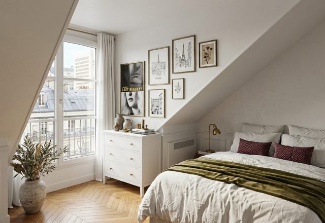 Cozy attic bedroom decor featuring slanted walls, a white dresser, and herringbone wood flooring overlooking a french balcony.