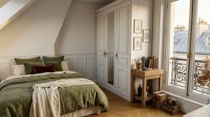 Cozy attic bedroom design featuring olive green bedding and a white French country wardrobe.