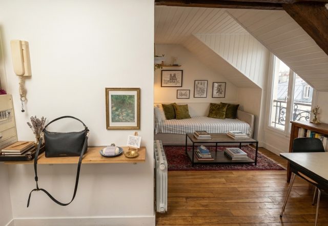 Cozy attic living room ideas featuring sloped ceilings, a daybed, and exposed wooden beams.