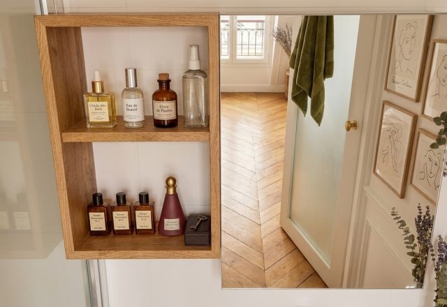 Modern bathroom open shelving featuring wood wall storage, amber glass bottles, and minimalist decor.