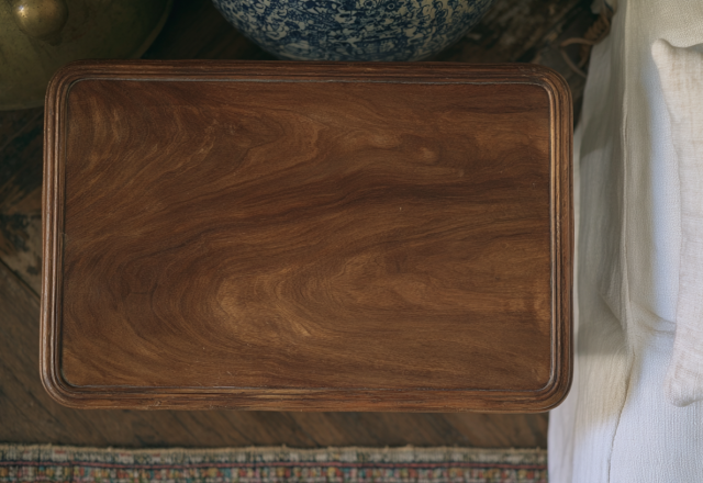 Overhead view of a classic wooden coffee table next to a white linen sofa.