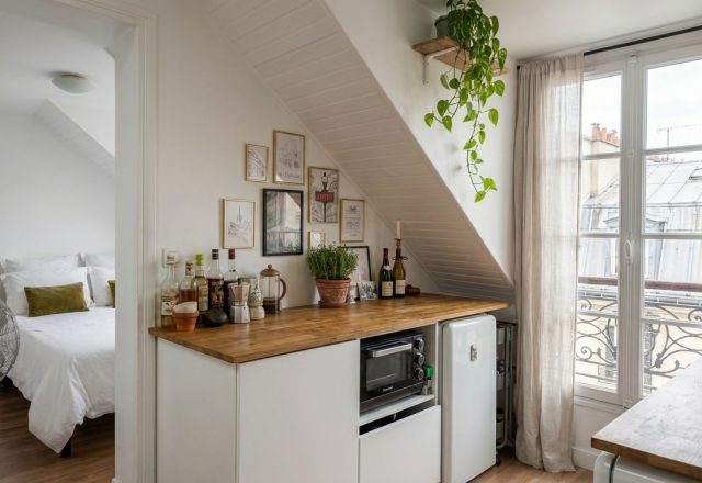 Bright small kitchenette design featuring butcher block counters and a sloped ceiling in an attic apartment.